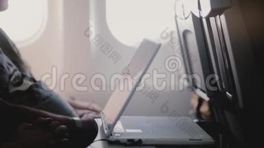 使用移动视频播放器设备在长时间的飞机飞行中近距离观看无聊飞机乘客视频的侧面视图。